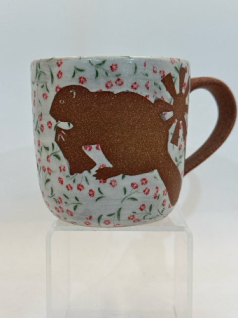 Mug With Beaver Design Against A Flower Background